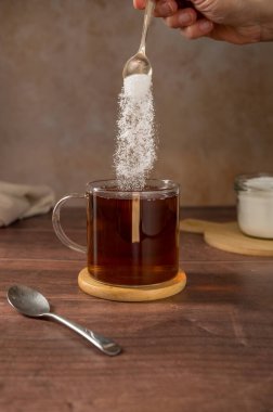 Bir fincan çaya tatlandırıcı tozu döküyorum. Şeker alternatifi, yiyecek ve beslenme