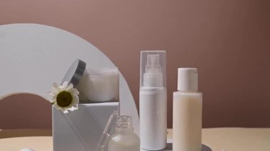 Papatya çiçekli beyaz kozmetik şişeler. Doğal kozmetik ürünleri, nötr arka plan