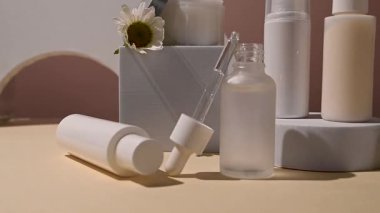 Papatya çiçekli beyaz kozmetik şişeler. Doğal kozmetik ürünleri, nötr arka plan