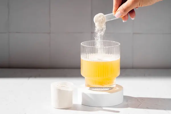Bir kepçedeki kolajen protein tozu. Bir bardak kolajen güzellik içeceği. Gıda takviyesi