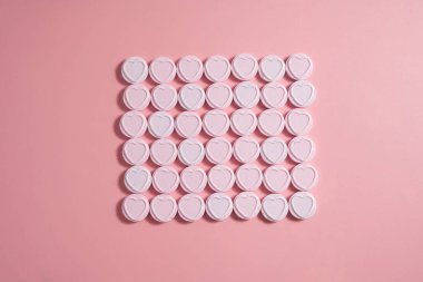 Pembe arka planda kalp şeklinde şekerler, soyut yemek aşkları.