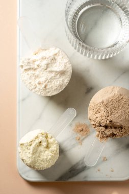 Kepçe içinde protein tozu. Sütlü protein tozlarının farklı tatları