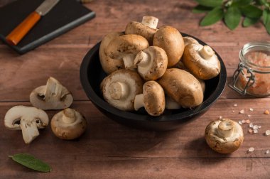 Kase içinde çiğ kahverengi mantarlar, pişmeye hazır bebek Bella mantarları..