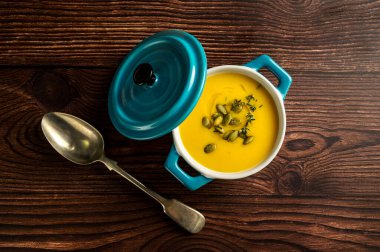 Seramik mavi kasede balkabağı çorbası, ahşap arka plan, üst manzara.