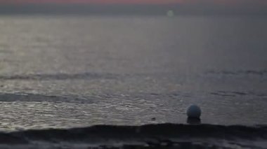 Akşamları deniz manzaralı tropik bir deniz manzarası ve arka planda turuncu gün batımı..