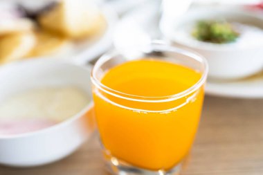 Masanın üzerinde portakal suyu ve cam.