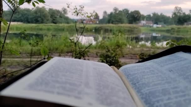 Mannen Läser Sin Bibel Närbild Flodsidan Rör Kameran Gorizontalt Religiös — Stockvideo