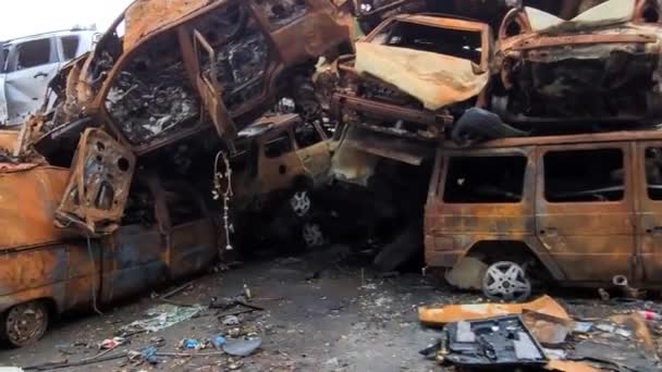 火箭袭击后烧毁的汽车的景象 俄罗斯对乌克兰的战争 火灾后的民用车辆 Irpin市的汽车坟场 一堆生锈的金属燃烧汽车的铁件 — 图库视频影像