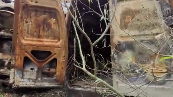 火箭袭击后烧毁的汽车的景象 俄罗斯对乌克兰的战争 火灾后的民用车辆 Irpin市的汽车坟场 一堆生锈的金属燃烧汽车的铁件 — 图库视频影像