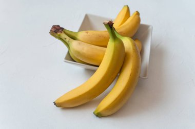 Masada tatlı olgun sarı muzlar. İzole edilmiş beyaz arka plan. Sağlıklı tropikal yiyecekler.