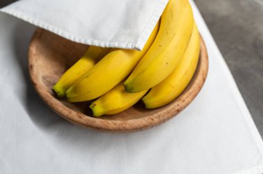 Tahta tabakta olgun sarı meyve muzları. Beyaz arka plan. Sağlıklı tropik yiyecekler. Üst görünüm.