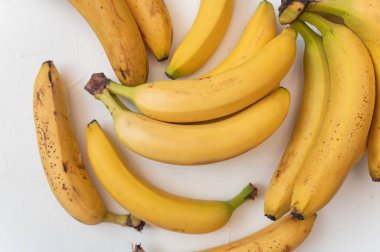 Masada tatlı olgun sarı meyve muzları var. İzole edilmiş beyaz arka plan. Sağlıklı tropikal yiyecekler.