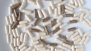 Dönüşümü kapat. Beyaz arka planda yumuşak beyaz ve gri haplar veya kapsüller..