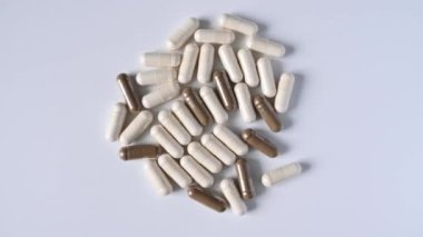 Dönüşü kapat Beyaz arka planda yumuşak beyaz ve gri haplar veya kapsüller.