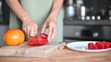 Tahta tahtada salata için domates doğrayan kadın. Mutfak bıçağıyla. Sağlıklı yemek..