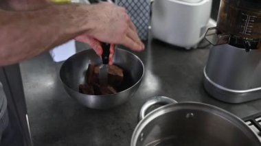 Bir adam kakao çekirdeklerini bıçakla öğütür.