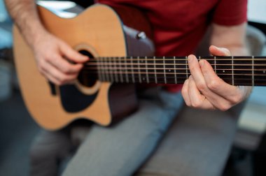 Akustik gitarda gitarist stüdyoda melodi çalıyor. Müzisyen enstrümanını kapat.