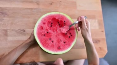 Karpuz yiyen bir kadın, yüzüne ve ağzına yakın çekim. çekici genç bayan vejetaryen ev mutfağında, sağlıklı bir yaşam tarzı ve iyi bir ruh hali var.