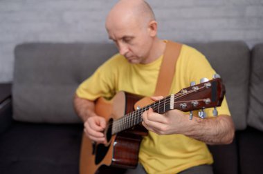 Akustik gitarda gitarist stüdyoda melodi çalıyor. Müzisyen enstrümanını kapat.