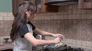 Kadın tavada taze mantar sote gaz alevi üzerinde, evde besleyici öğle yemeği hazırlıyor