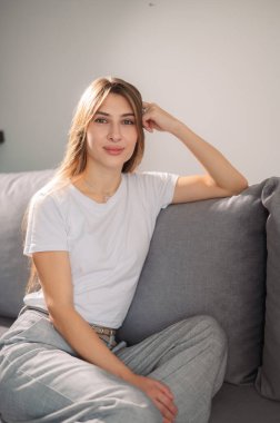 Portre, hafta sonu bahar tatili için oturma odasında rahatlamak için gülümseyen genç ve kadın. Mutlu, kaygısız ve kampüs yurdunda huzur içinde yaşayan bir kadın.