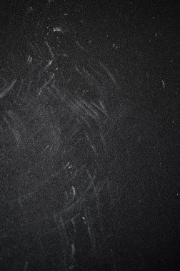 Yıpranmış tebeşir tozlu yüzey derin çizikler taşıyor, karanlık arka plana karşı yaşlanma ve fiziksel sıkıntıları ortaya çıkarıyor.