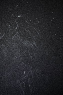 Koyu, pürüzsüz bir zemin üzerinde un dökülüyor, aşçılık sanatını vurguluyor, ince beyaz toz dokulu arka planda yayılıyor.