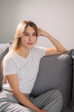 Portre, hafta sonu bahar tatili için oturma odasında rahatlamak için gülümseyen genç ve kadın. Mutlu, kaygısız ve kampüs yurdunda huzur içinde yaşayan bir kadın.