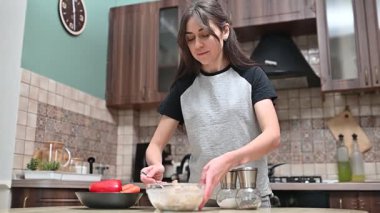 Taze mantarların üzerine manuel değirmenle tuz öğüten kadın, çağdaş mutfak ortamında sağlıklı yemek yapmak için malzemeler hazırlıyor.