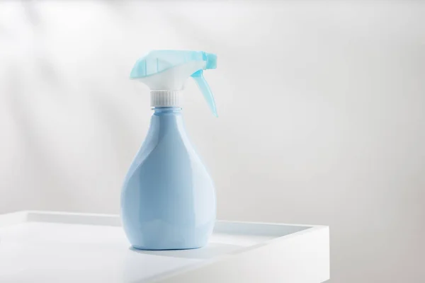 Blue air freshener spray bottle on a simple background