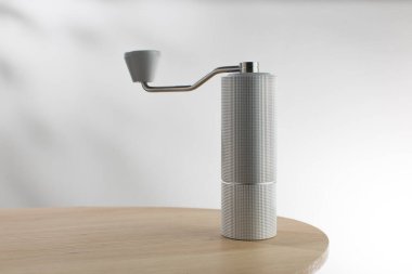 Ahşap masada elle kahve öğütücü.