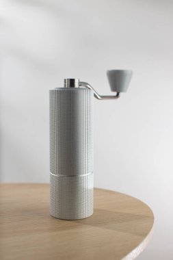 Ahşap bir masada el yapımı kahve öğütücüsü..