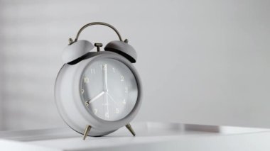 Tahta masada ve sabah ışığında minimalist gri alarm saati
