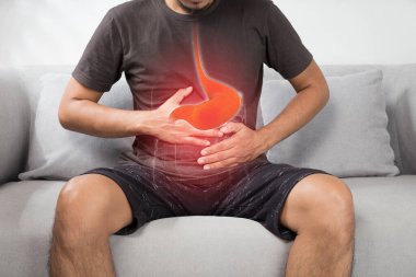 Acid reflux or Heartburn, The photo of stomach is on the men's body against gray Background, Bad health, Male anatomy concep clipart