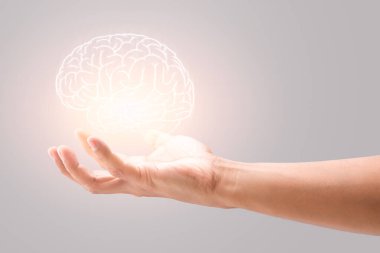 Man holding brain illustration against gray wall background. Concept with mental health protection and care.	