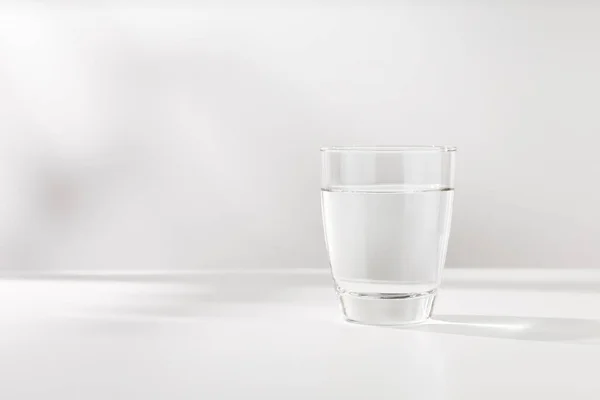 Καθαρό Νερό Στο Ποτήρι Είναι Στο Λευκό Ξύλινο Τραπέζι — Φωτογραφία Αρχείου
