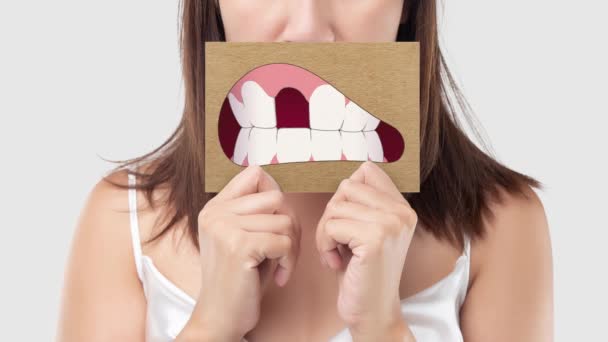 アジアの女性保持A茶色い紙とともにザ壊れた歯の漫画 — ストック動画