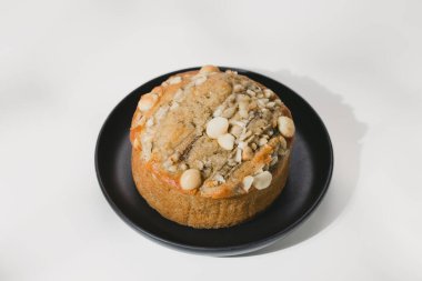 Beyaz ahşap masada siyah tabakta Tayland muzlu keki.