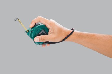 Gri arka planda mezura tutan bir erkek el..