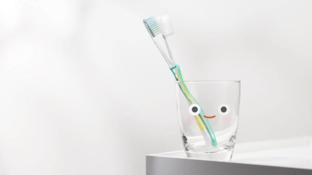新しい朝を迎えるために水と歯ブラシの笑顔のガラス — ストック動画
