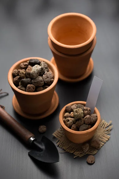 Pumice or planting material and clay pots for plant propagation.