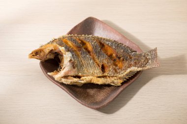 Japon usulü seramik tabakta Tayland usulü pilav ile kızartılmış tilapia..