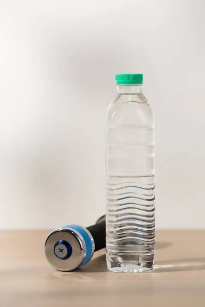 Dumbbells and drinking water in a plastic water bottle.