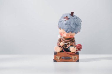 Klasik bir valizin üzerinde uyuyan bir çocuk figürü. HIRONO Reshape figürleri, POPMART tarafından ahşap bir masa ve beyaz zemin üzerinde satılan bir iyileştirme serisidir..