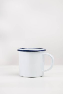 Beyaz ahşap bir masanın üzerinde beyaz bir su bardağı, içerik oluşturmak için üzerinde boş bir alan var..