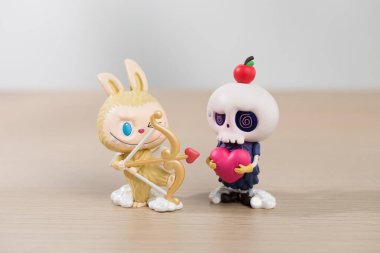 Bangkok\ Tayland - 12 Mayıs 2024: Labubu ve Tycoco canavar günlüğü, iki tuhaf figür, yaylı bir tavşan ve elma tutan kafatası kafalı bir figür, eğlenceli bir etkileşime giriyorlar.