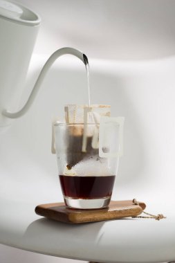 Bir Drip Bag suyu düzenli bir şekilde kahve telvesinden süzerek demleme tekniklerindeki hassasiyeti gösterir..