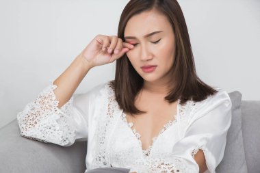 A woman in a white satin nightgown experienced itching on her eyelid due to blepharitis. The concept of the image aims to convey the importance of self-care in health and medical treatment. clipart