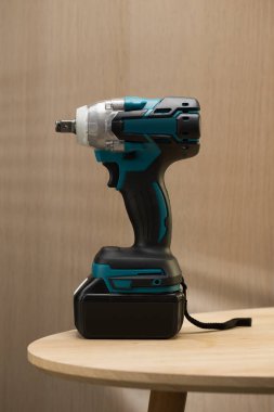 Kablosuz bir elektrikli matkap ve tornavida, her tüccar için esastır, ahşap bir masanın üzerinde, çok yönlülüğünü ve rahatlığını gösterir..