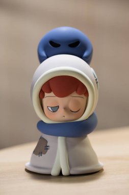 Bangkok, Tayland - Kasım 2024: Kafasının üstünde mavi bir ruh bulunan battaniyeli bir çocuk figürü. Emor Outsider serisinden bir figür